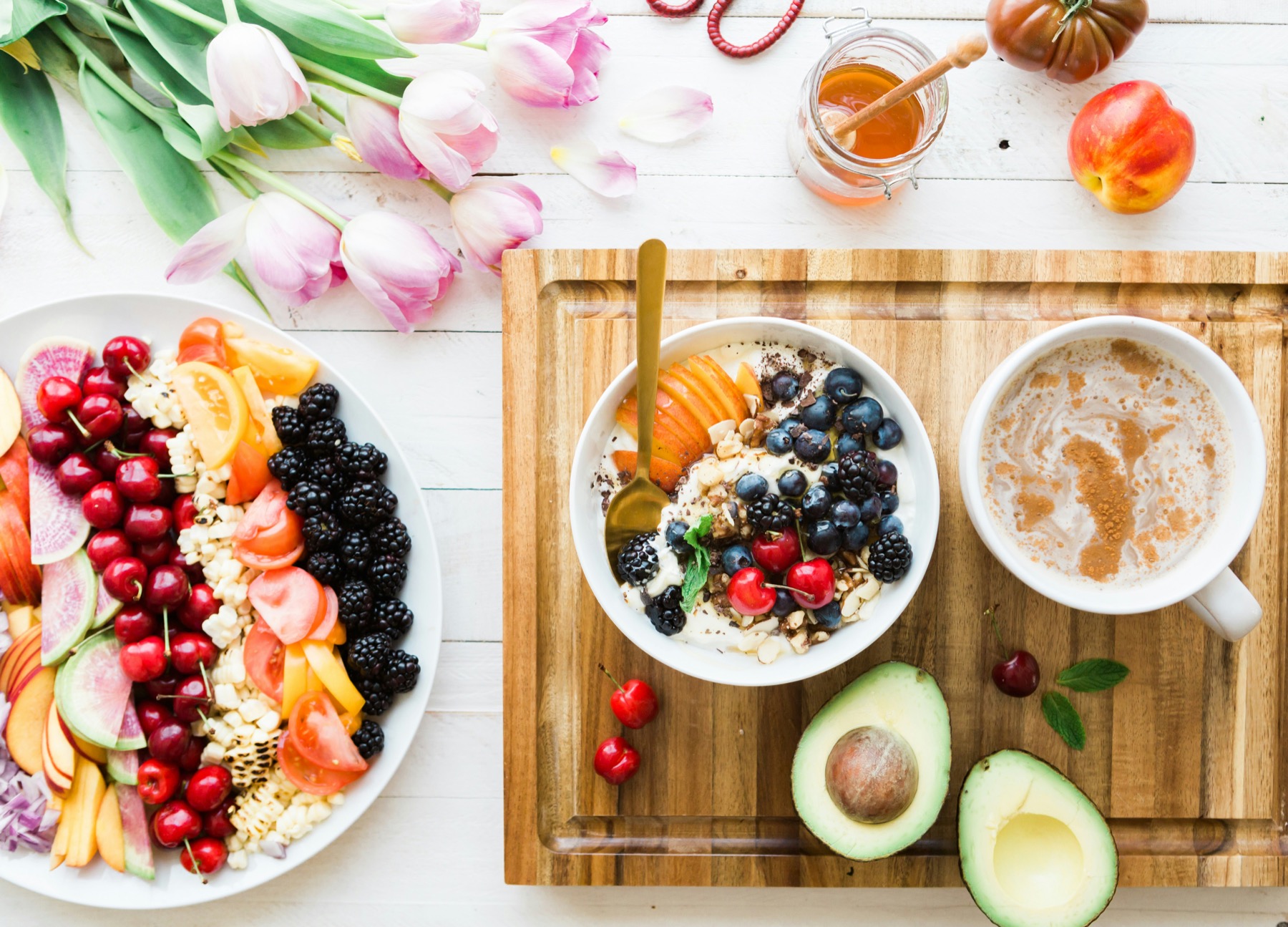 A table with colorful whole foods and a warm drink.