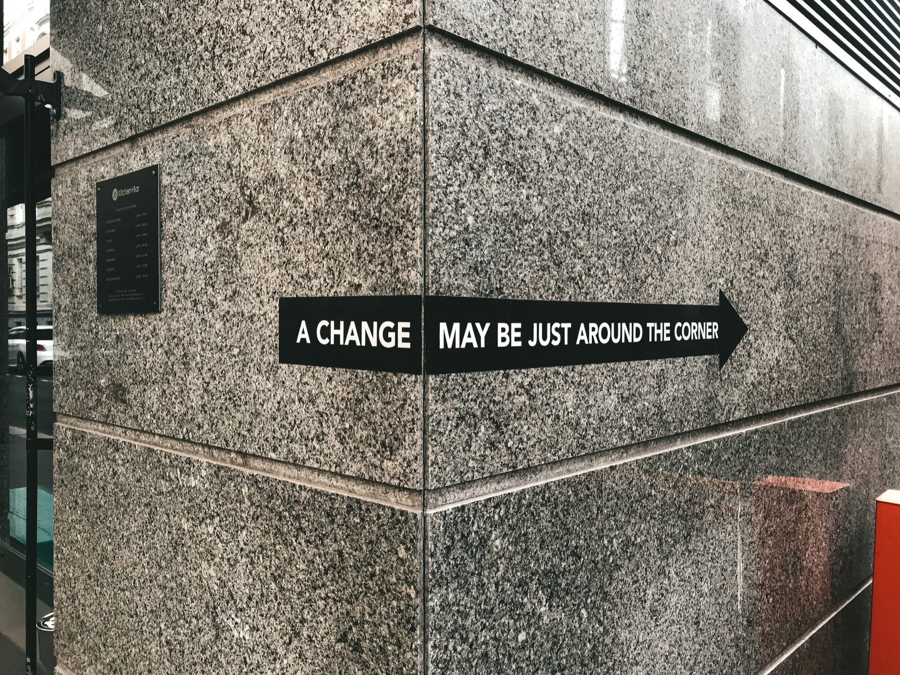 A sign on a wall saying a change may be just around the corner.