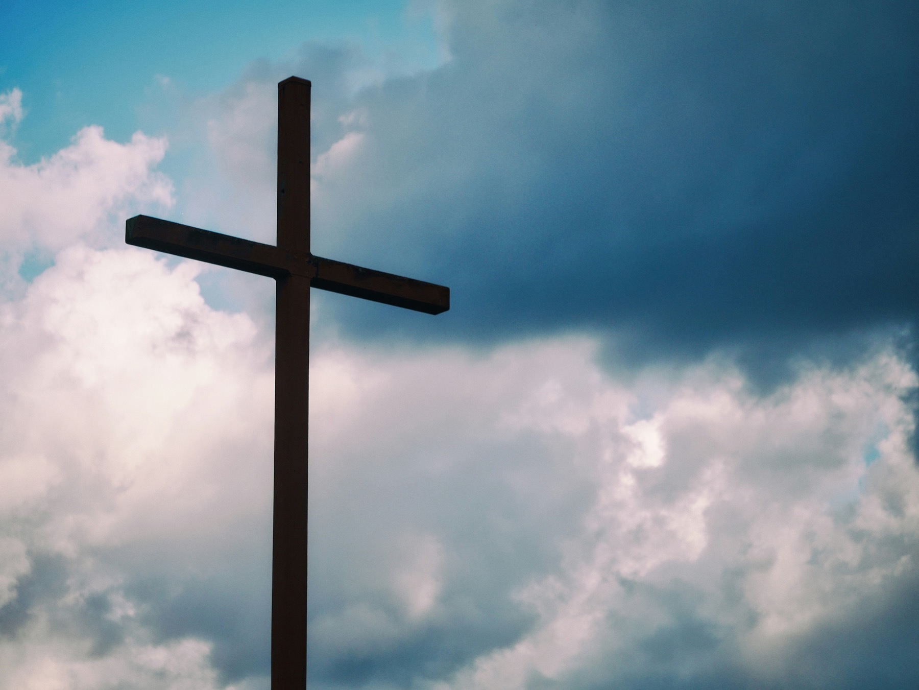 A wooden cross lifted against the sky.
