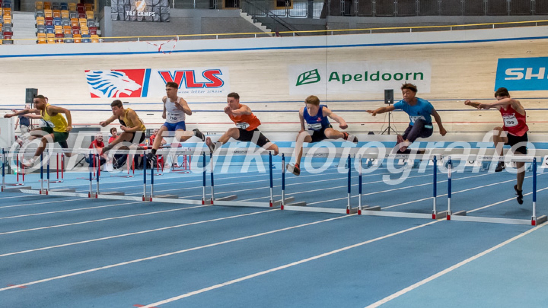 Indoor hurdles race showing Robin's high-performance sports background.